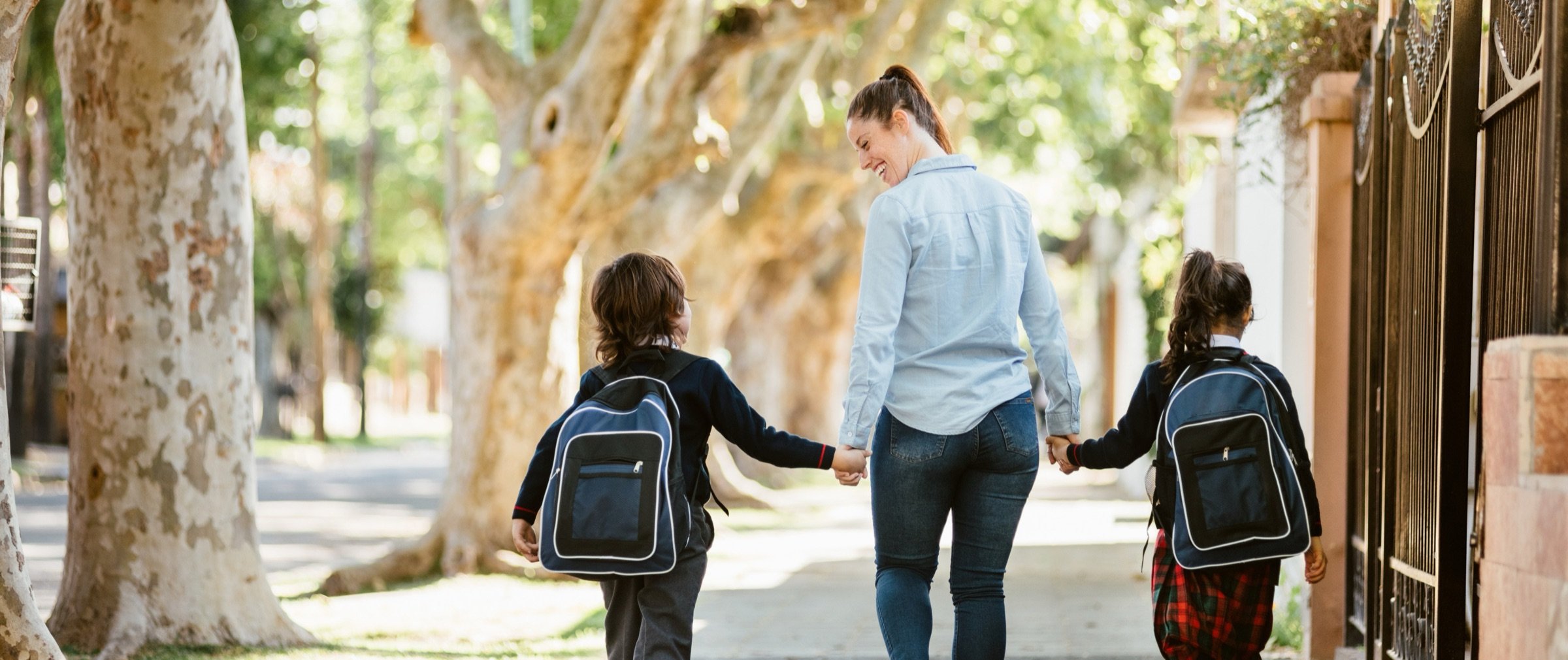 A mother walking two children to school